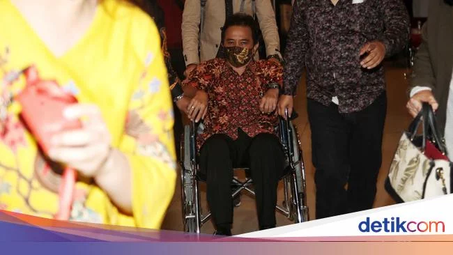 Status Tersangka Bikin Roy Suryo Syok hingga Drop Dibantu Kursi Roda