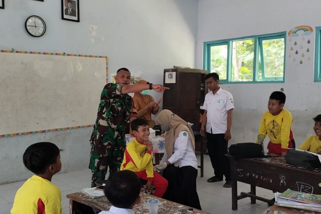 Dukung Kesehatan Masyarakat, Serka M. Romi Dampingi Vaksinasi Campak di SDN Kartagena Laok 2